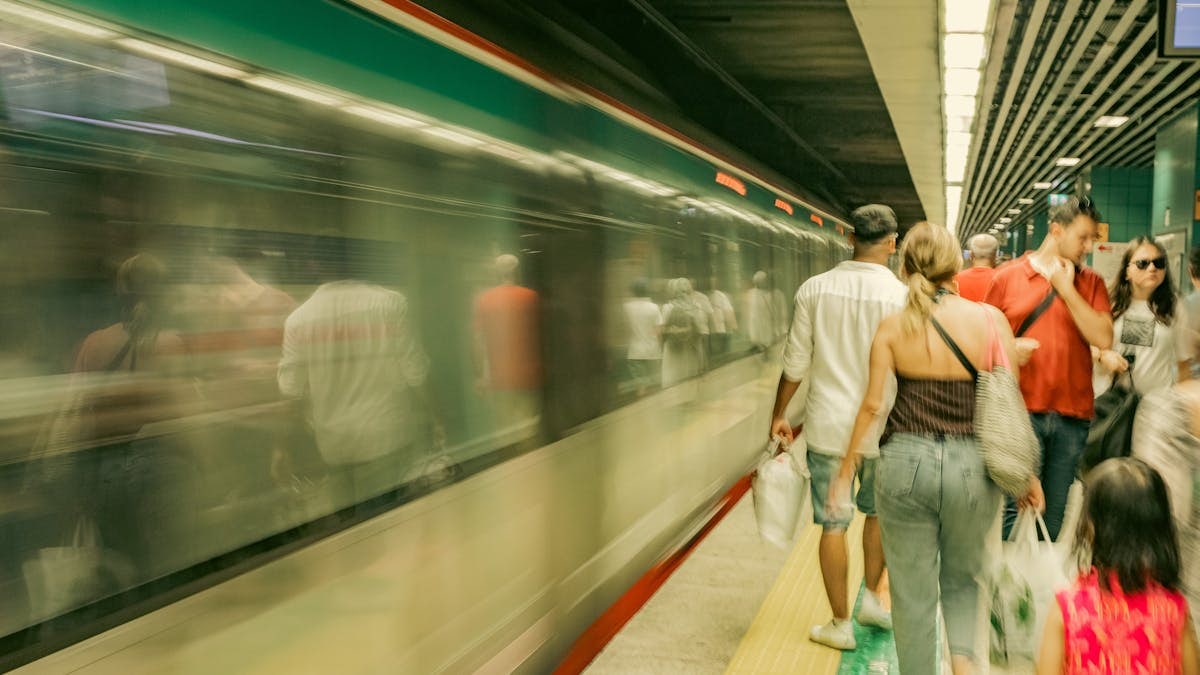 Commuters navigate a bustling subway platform as a train speeds by in İstanbul, Türkiye.